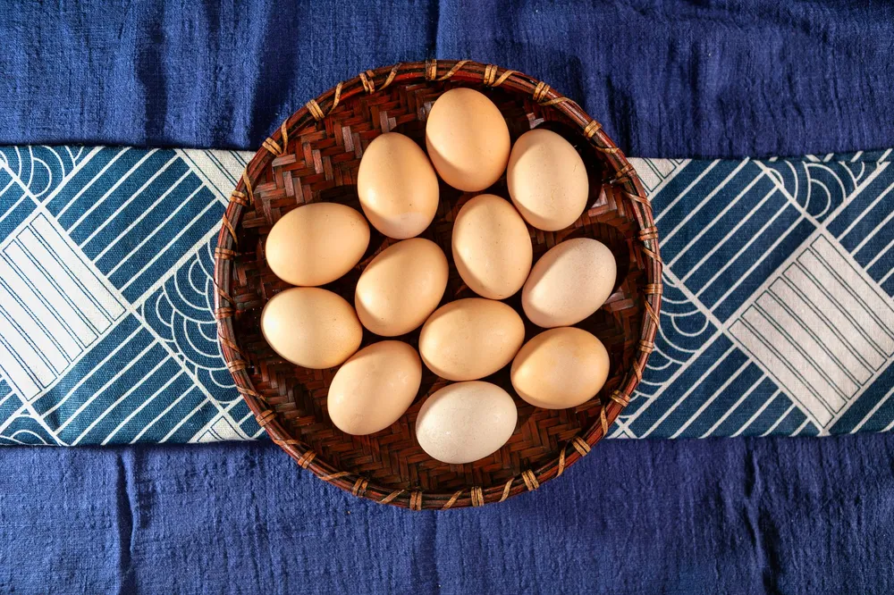 Panier d'œufs frais du jour posé sur une nappe