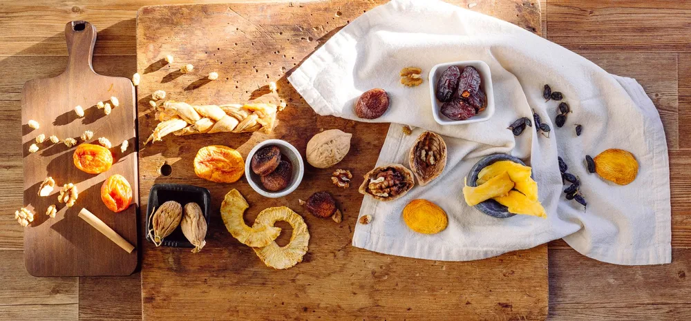 Abricots secs, raisins, figues et noix sur une planche en bois rustique, ingrédients pour un far breton sans pruneaux