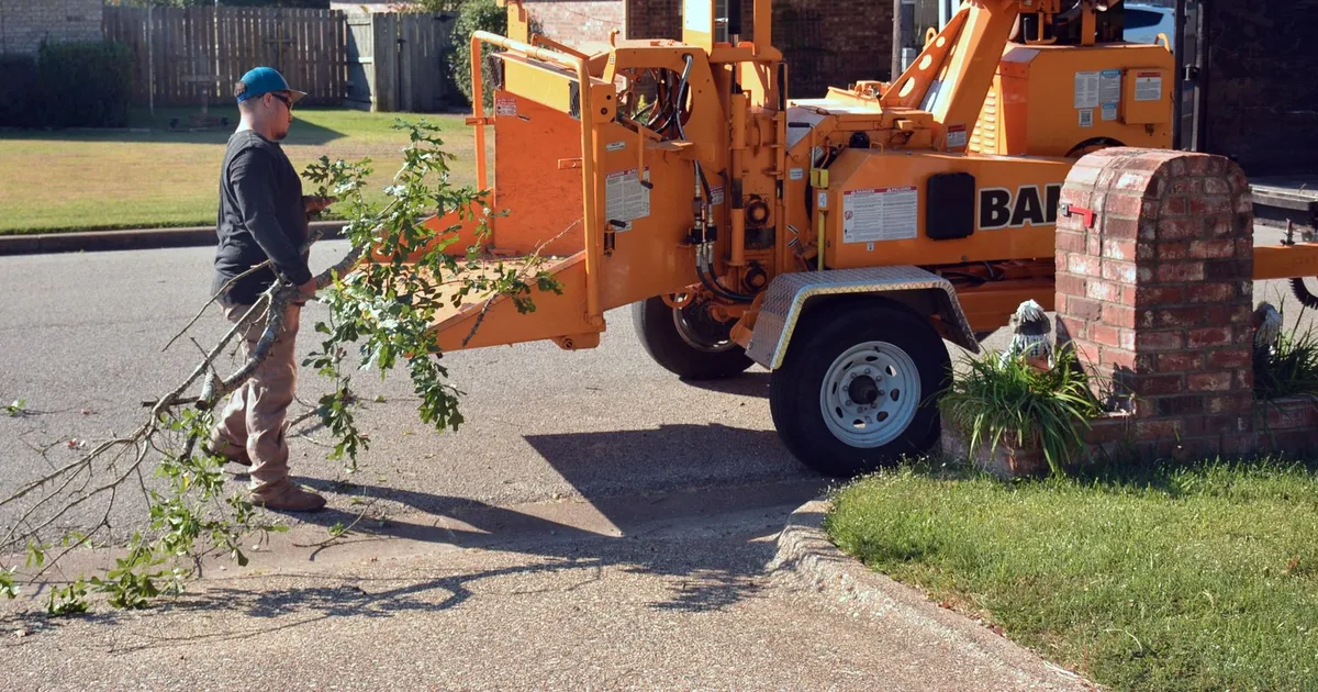 Broyeur de végétaux et tas de branches de taille dans un jardin de campagne
