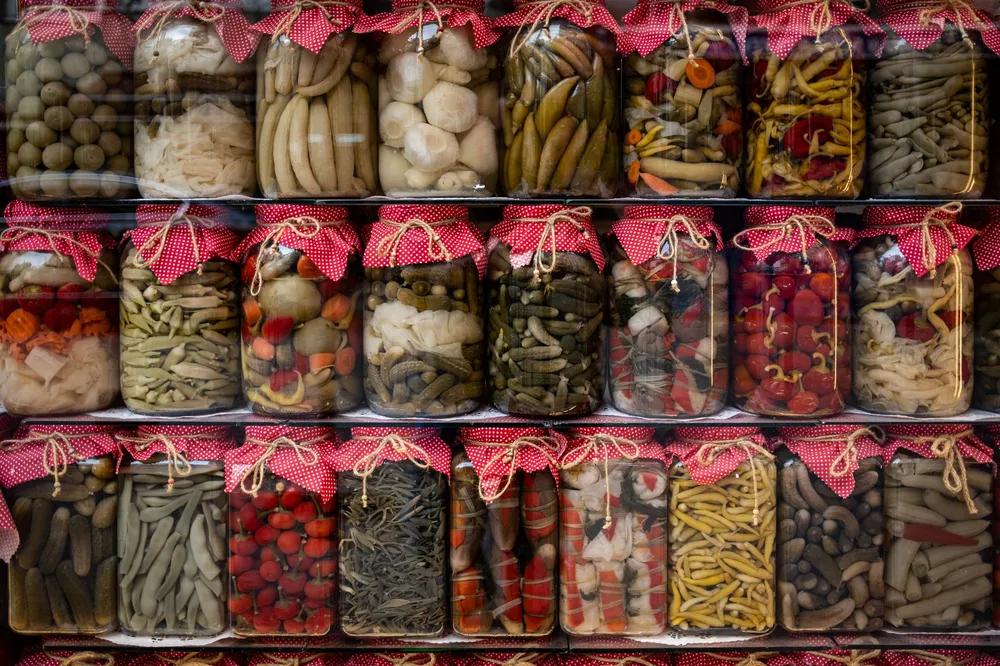 Bocaux de conserves de légumes multicolores alignés sur des étagères