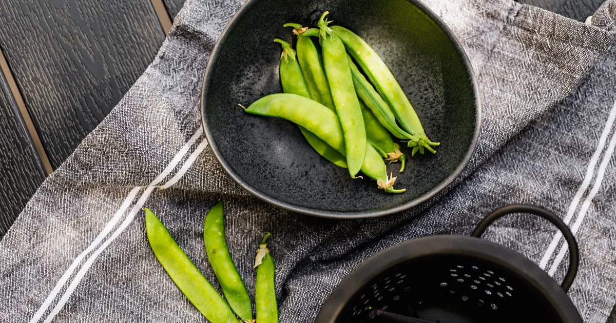 Haricots verts frais du potager équeutés dans un bol